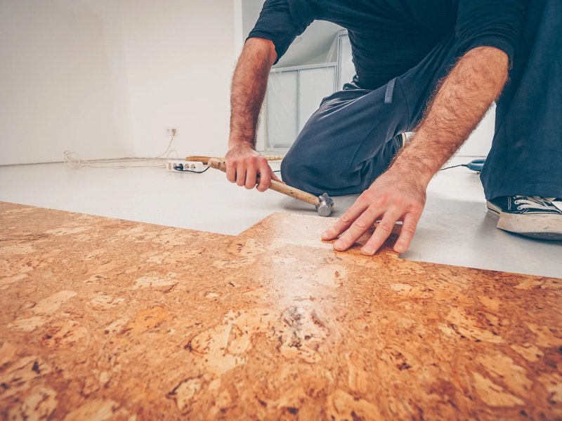 Person installing cork flooring from C G Interiors in San Leandro, CA