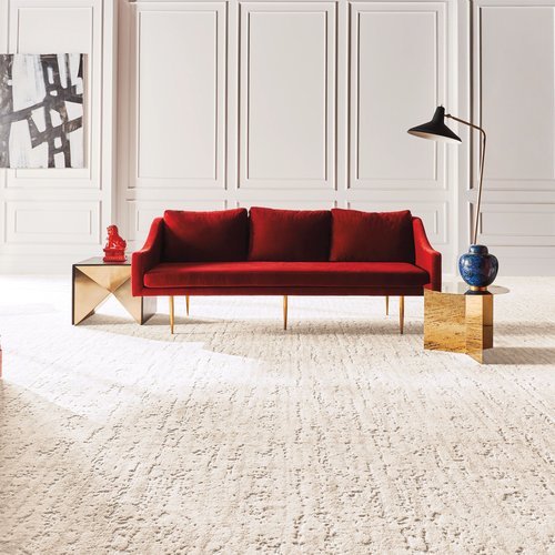 Bright living room with a red velvet couch and beige textured carpet from C G Interiors in San Leandro, CA