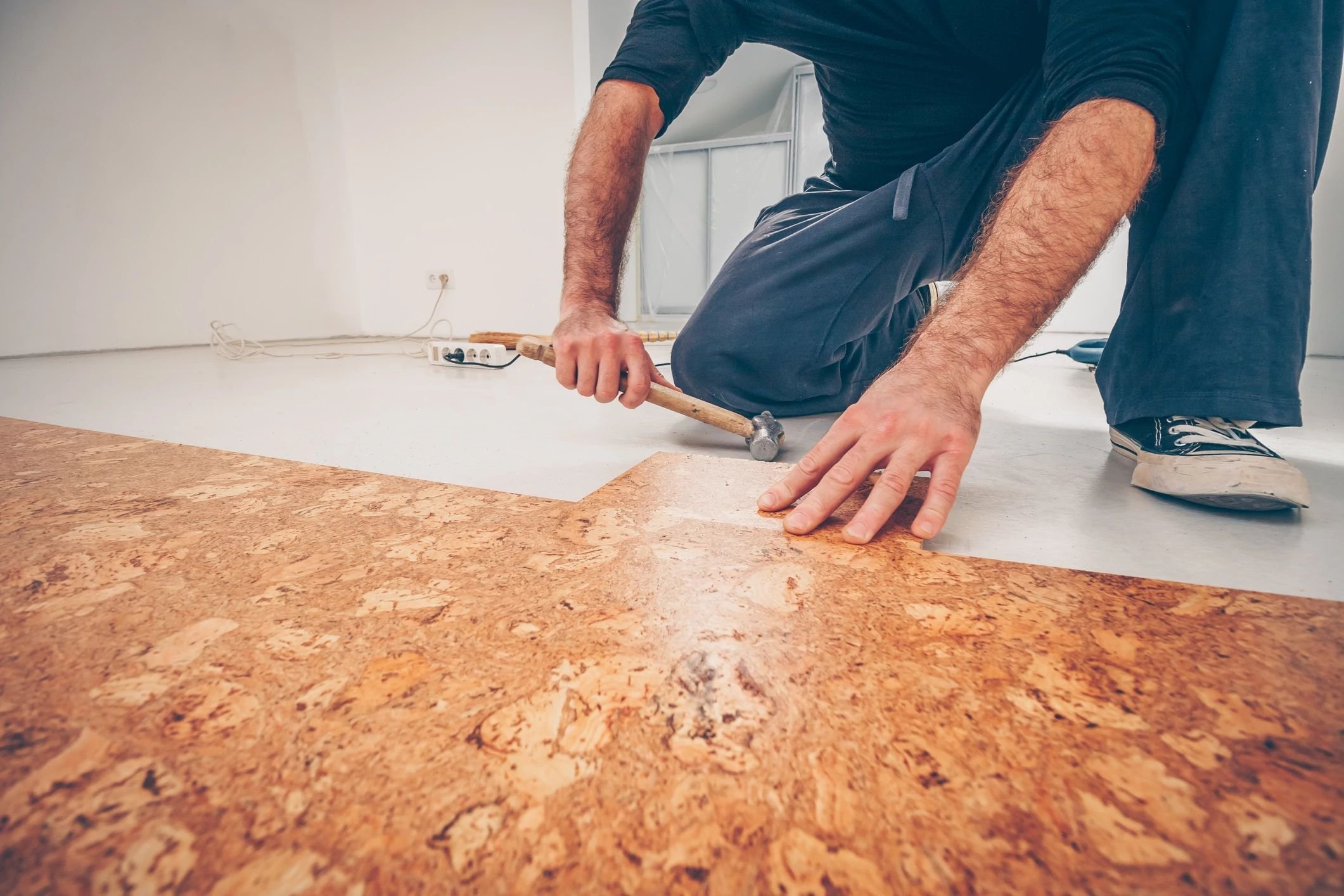 Person installing cork flooring from C G Interiors in San Leandro, CA