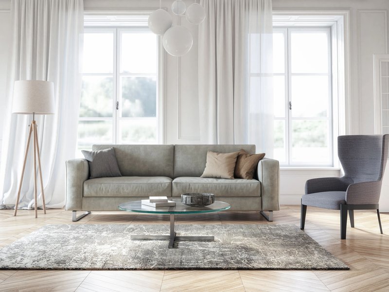 Bright modern living room with a gray couch and area rug, and large windows with white curtains - Window Treatments from C G Interiors in San Leandro, CA